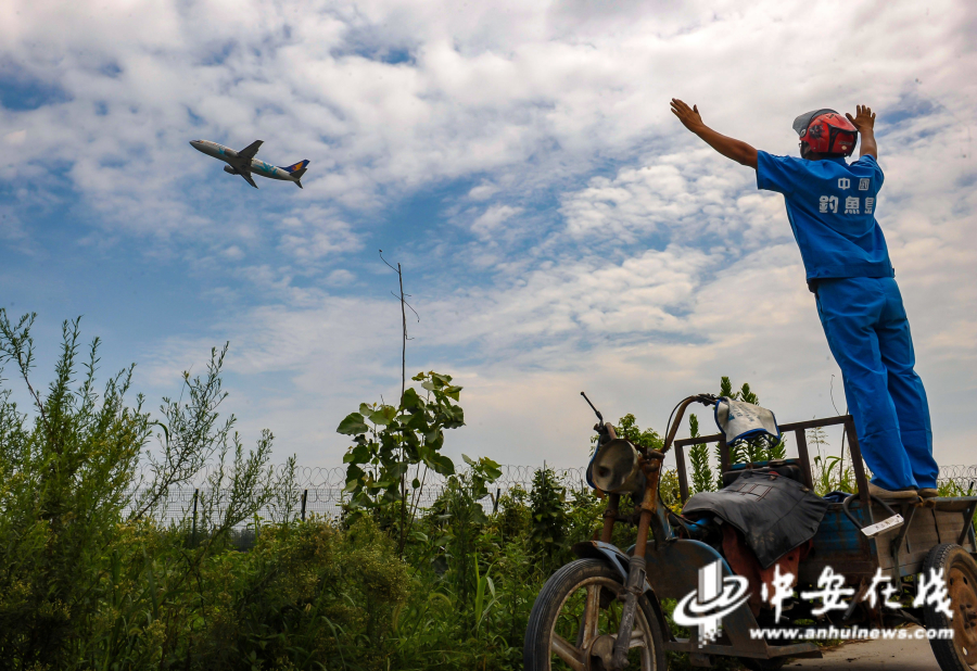 2012年，骆岗机场外，骑三轮的行人与来往的飞机挥手示意.JPG