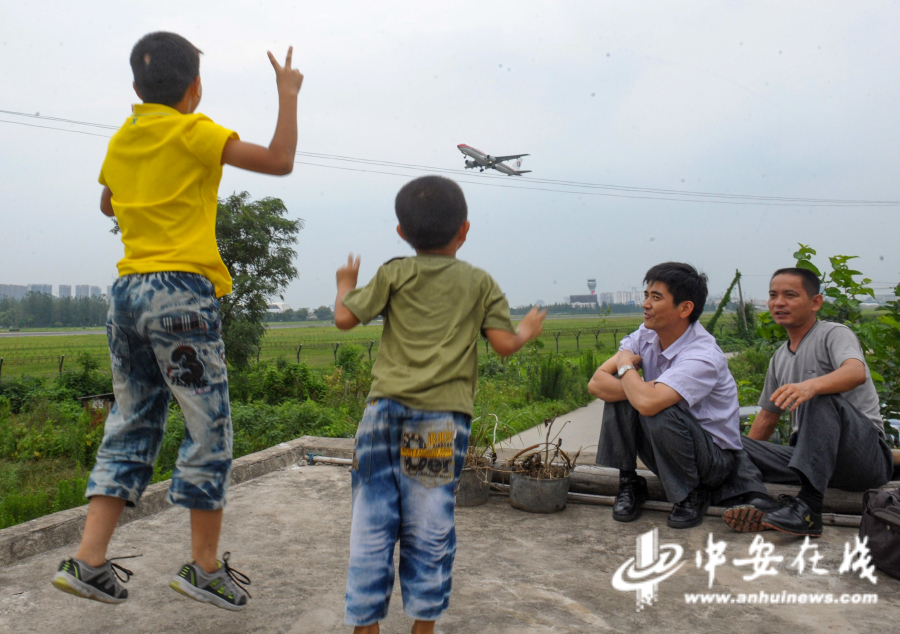 2012年8月23日，住在骆岗机场跑道旁边村庄的孩子们与头顶的飞机挥手.JPG