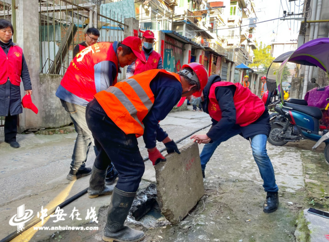 志愿者为社区居民清理疏通下水道.png