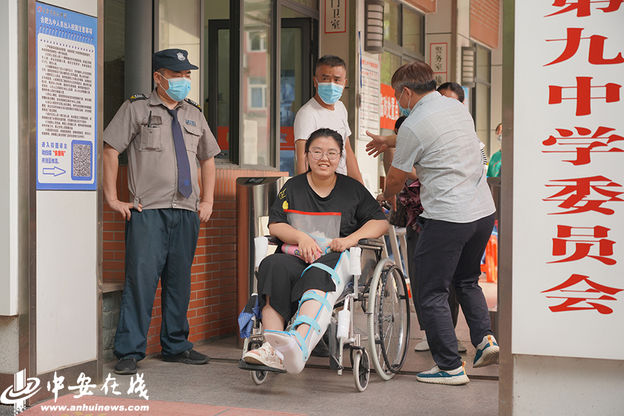 14.一位腿受伤的考生坐着轮椅走出校门，家长快速上前迎接。.JPG