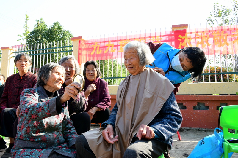 10月21日，阜南县黄岗镇耿寨村老人们在村老年食堂大院内免费理发.jpg
