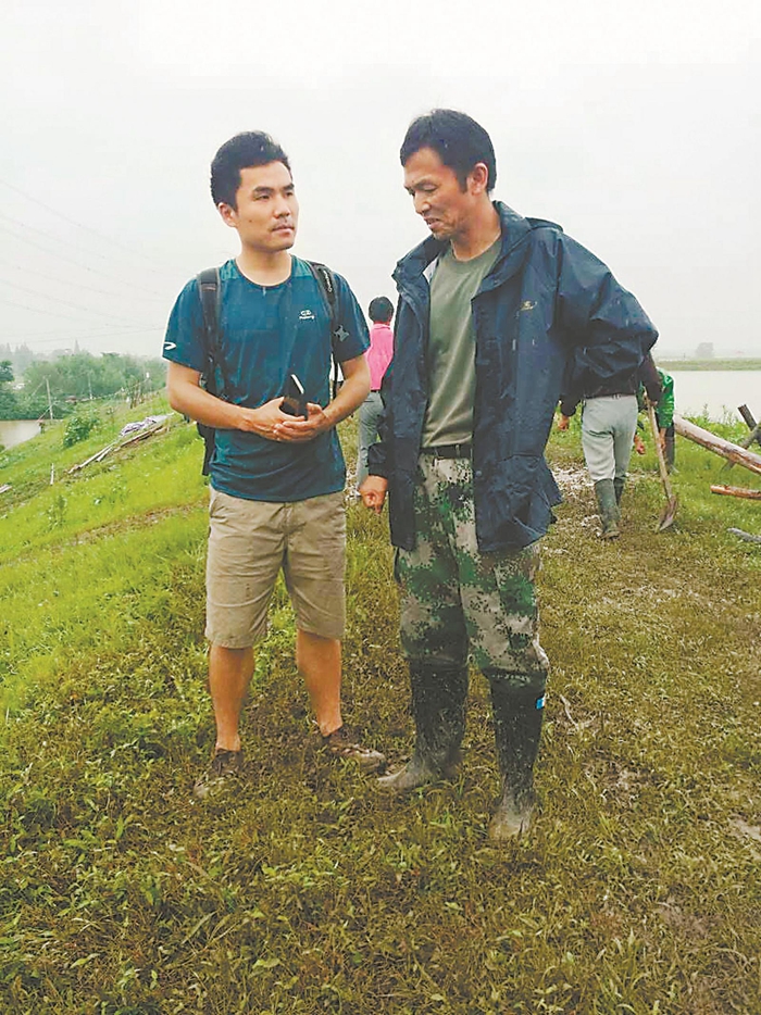 芜湖传媒中心记者尹强（左）采访防洪大堤上的村干部。.jpg